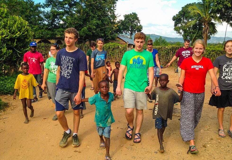 Volunteers walk with children.