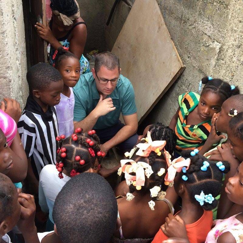Tim-in-Haiti-talking-to-kids Tim, the founder of Many Hands for Haiti, speaks at an event.